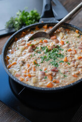 One pot meal with a quick homemade cooked white bean soup with canned beans in a skillet on hot...