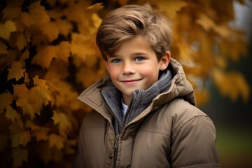 portrait of a little boy in a jacket on a background of autumn leaves