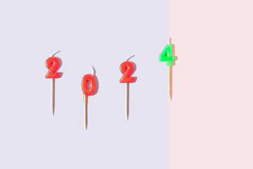 Candles in the shape of the numbers 2024. New Year . Pastel multi colored background. Flat lay. Copy space.