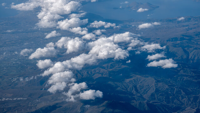 An aerial view of white clouds circling in the sky with mountainous vistas above Hokkaido Japan.