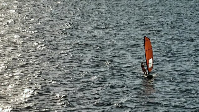 Aerial view of surfing in the sea. Active recreation and tourism on the ocean, surfing the waves. High quality 4k footage