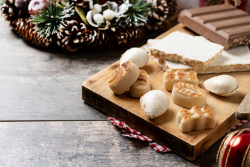 Fototapeta na wymiar Traditional Christmas sweet, nougat and Christmas sweet almonds on wooden table. Copy space