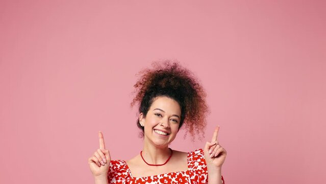 Young latin woman wear red casual clothes pointing indicate index finger overhead on workspace area copy space mock up isolated on pastel plain light pink background studio portrait. Lifestyle concept
