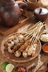 Fototapeta na wymiar Sate taichan is a variation of chicken satay grilled and served without peanut or ketjap seasoning unlike other satays. It is served with sambal and squeezed key lime,