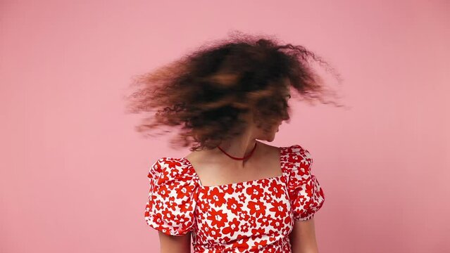 Fun fancy vivid smiling happy young latin woman wear red casual clothes dance waving fooling around have fun enjoy play fluttering hair isolated on pastel plain light pink background Lifestyle concept