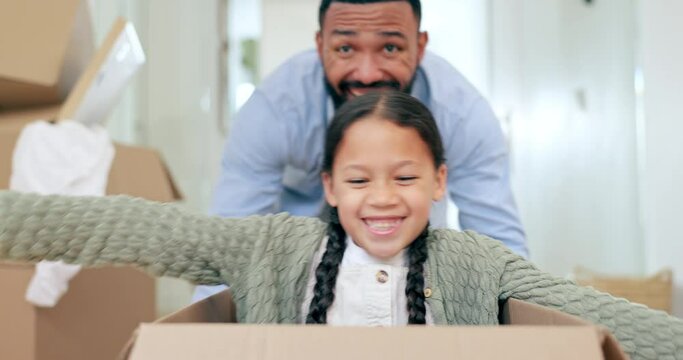 Happy family, moving in new home pushing box for real estate, property or investment and playing together. Excited father and child exploring house, apartment or renovation with boxes in relocation