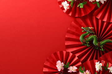 Abstract composition with paper fans, dragon, sakura on red backdrop, celebrating Chinese New Year 2024. Asian art and culture in a festive design.