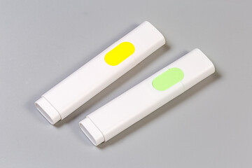 Two highlighter pens differenr colors on a gray background