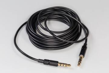 Analog audio cable with mini stereo connectors on gray surface
