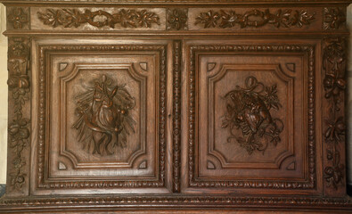 Old vintage wardrobe furniture with ornamental doors and retro colors of wooden surfaces close up
