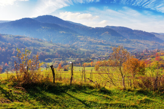 mountainous rural landscape with fence on the field. countryside scenery with rolling hills in autumn
