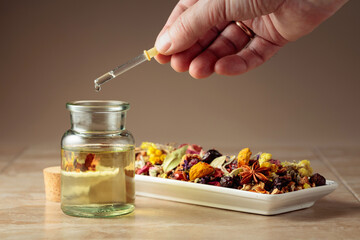 Dropping essential oil or herbal tincture into a glass bottle.