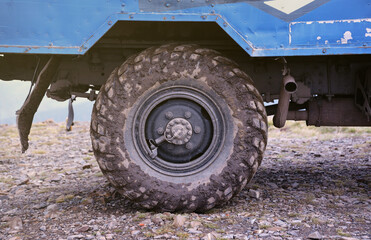 Wheel closeup in a countryside landscape with a mud road. Off-road 4x4 suv automobile with ditry...