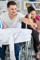 handsome handicapped man in wheelchair watching tv with his girlfriend