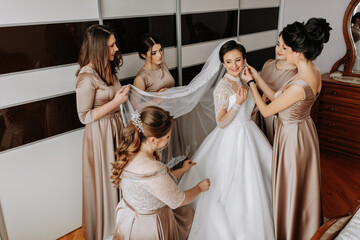 The bridesmaids help the bride get dressed. Preparation for the wedding. Morning of the bride