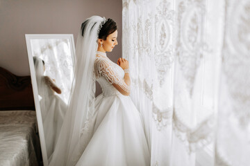 fashion portrait of a beautiful bride in a luxurious wedding dress with lace and crystals....