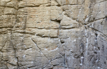 Light coarse natural rock stone background. Mining cliff rough front surface. Big limestone stack backdrop. Heavy grunge damaged granite block texture. Crack antique medieval stony facade for design