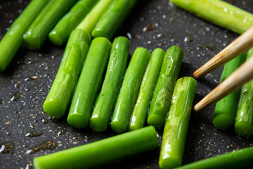 にんにくの芽をフライパンで炒める調理シーン。
