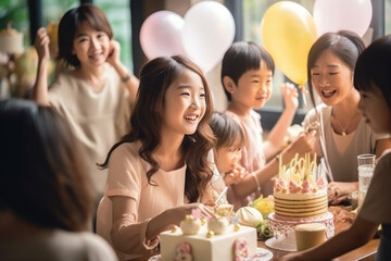 Obraz premium A beautiful young girl and her Asian family have fun celebrating their birthday with a birthday cake and candles while smiling for the camera. Celebrate children's birthdays with family