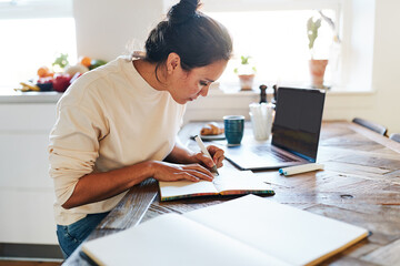 Woman sketching in a book at a table