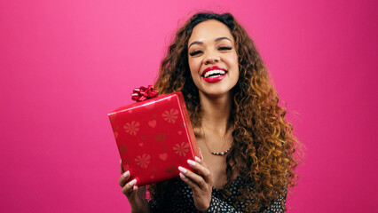 Beautiful young woman poses with gift box pink studio, Valentines or anniversary