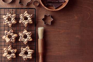 Fresh baked homemade star-shaped cookie with chocolate on the grid on the wooden table, copy space - Powered by Adobe