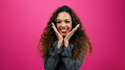 Cute young woman poses with hands under chin, dressed up for Valentine's Day