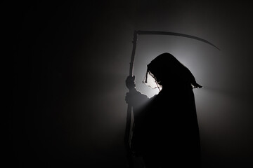 silhouette of death with a scythe. Dark reaper on a black background. Skeleton, skull, silhouette...