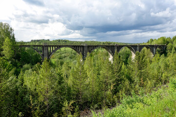 Railway bridge across the river in the south of the Kama region. The old Big Sars viaduct. The abandoned Oktyabrsky viaduct in the Perm Region. Russia.