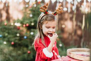 Christmas in july. Child waiting for Christmas in wood in july. portrait of little girl drinking...