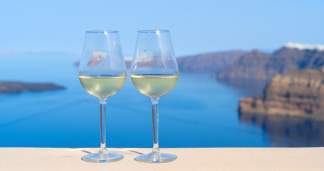 two glasses of white wine with Aegaen sea in background, Greece