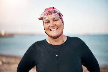 Woman wearing a wetsuit and cap smiling before an open water swim