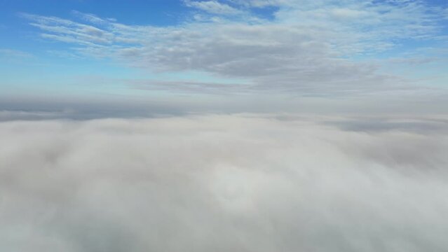 Beautiful sky above the low clouds with sunlight over the fluffy clouds. Flying Drone view.