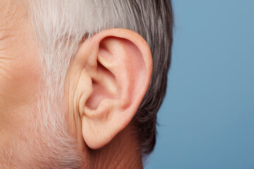 In a closeup of an elder man's ear, the effects of hearing loss become apparent, symbolizing the challenges that can accompany aging and impacting one's overall health. - obrazy, fototapety, plakaty
