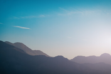 Mountains silhouettes at dawn morning haze, moody landscape