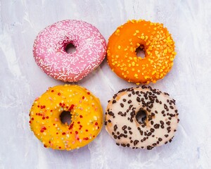 Variety of colorful donuts arranged on a table against a white background