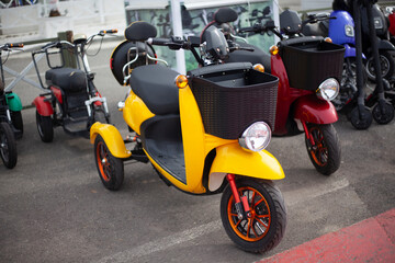 Moto electric vehicles are in a row. Electric bike rental. Headlights at two wheeled vehicles.