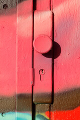 Türknauf und Türschloß an einer rot bemalten Holztür, Deutschland