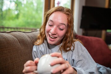 Young woman looking inside her cup with a cheerful look on her face