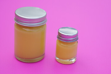 Bottles of homemade Thai herbal ointment, pink background. Concept, Thai local wisdom to use fragrant medicinal herbs to make inhaler and massage balm.              