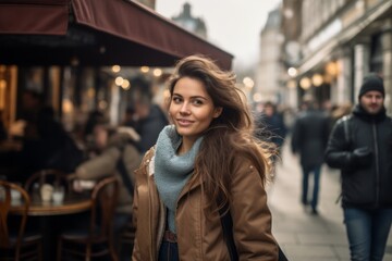 Beautiful young woman walking in Paris, France, wearing a coat and scarf