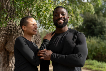 Portrait of smiling athletic couple in park