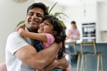 Father hugging daughter at home