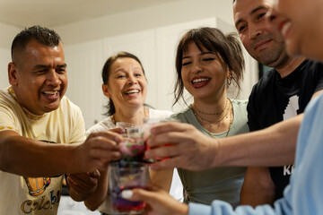 Members of family raising celebratory toast in kitchen