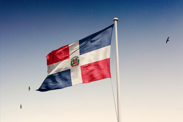 Dominican Republic flag fluttering in the wind on sky.