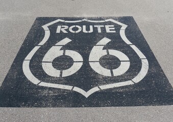 Vintage Route 66 highway sign painted on an asphalt highway in a rural area