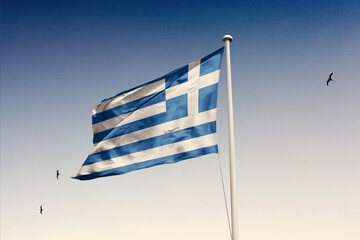 Greece flag fluttering in the wind on sky.