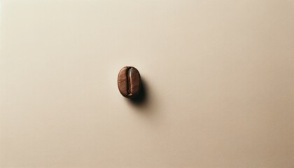 A simplistic composition with a single coffee bean lying on a beige surface, showcasing minimalism