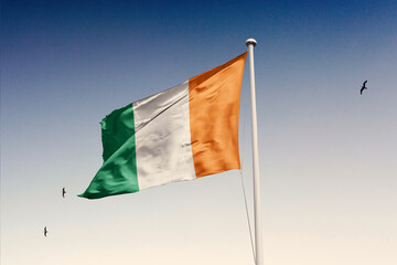 Ivory CoastIvory Coast flag fluttering in the wind on sky.