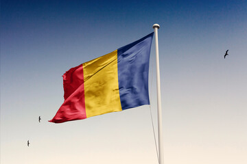 Romania flag fluttering in the wind on sky.